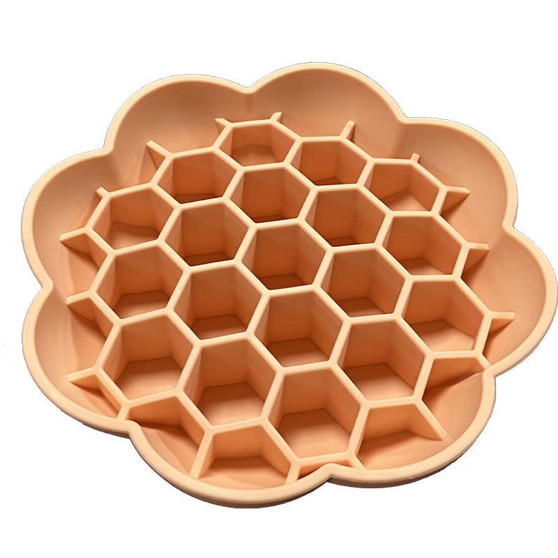 Flower-shaped silicone dog slow-feeder bowl with hexagonal compartments in peach color.