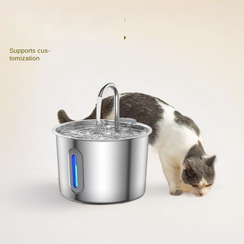 Stainless steel pet water fountain with automatic circulation and anti-leak design, blue LED indicator, cat nearby.
